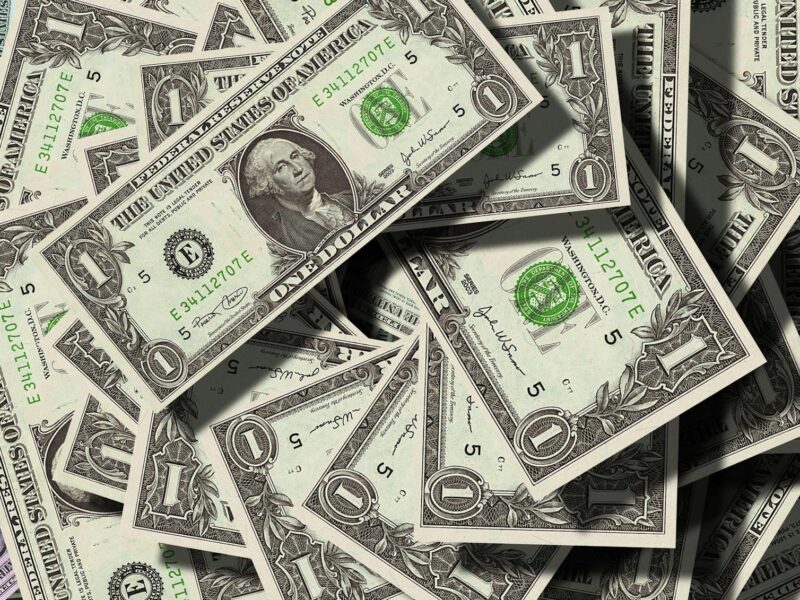 Close-up of scattered US dollar bills symbolizing finance and wealth.